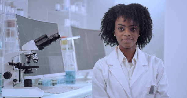 istock African female doctor in laboratory. Satisfied with her work. Looking at camera 1312459219