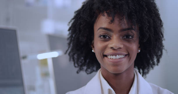 African female doctor in laboratory. Satisfied with her work. Smiling to a camera Young successful female scientist or pharmacist in whitecoat african american scientist stock pictures, royalty-free photos & images