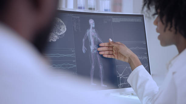 istock African ethnicity doctors working in laboratory. Studying human skeleton and virus models. Discussing 1312459246