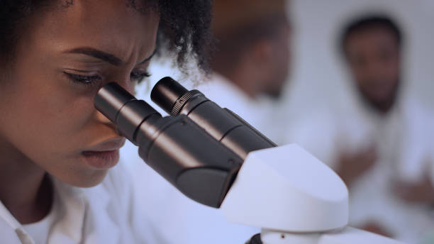 istock Worried female scientist studying medical samples. Team discussing in background 1312460205
