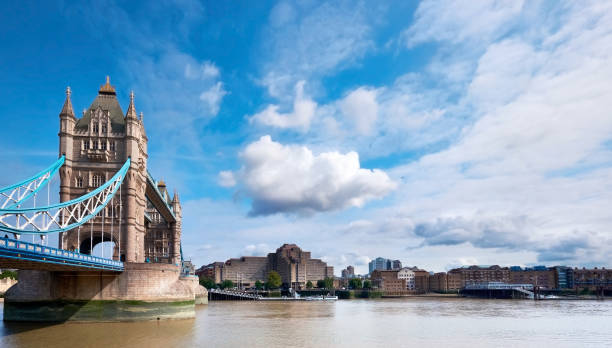 istock Tower Bridge on a bright sunny day with blue sky and clouds. Calm water with reflections. London, England, UK 1312460423
