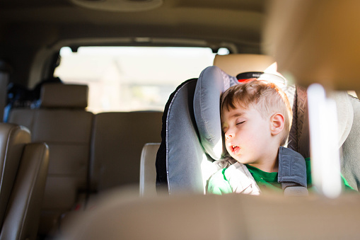A young child sleeping in car seat