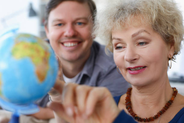 istock Elderly woman with her son is looking at globe 1312462803