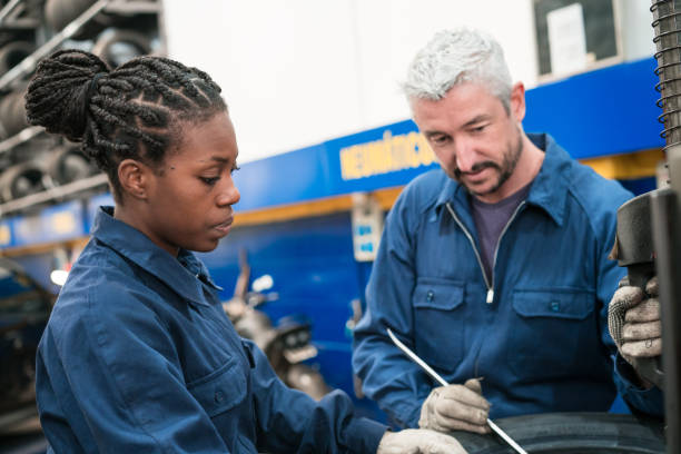 istock Auto mechanic and female apprentice balancing wheel 1312466457
