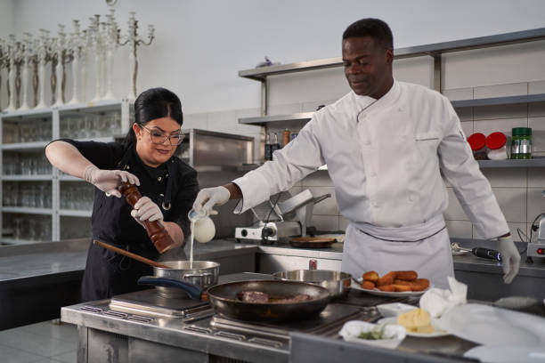 istock While female assistant seasoning the puree, chef adding the milk, for rich taste 1312468509