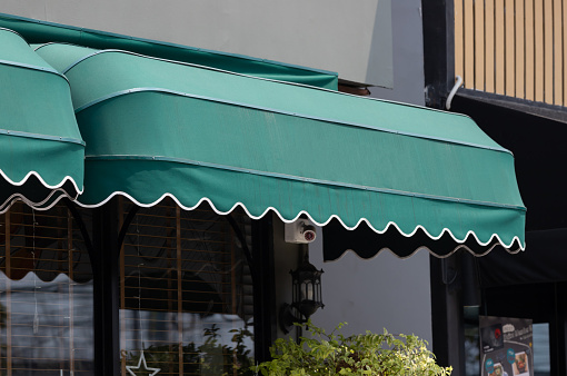 green curve awning of shop window. exterior canvas roof.