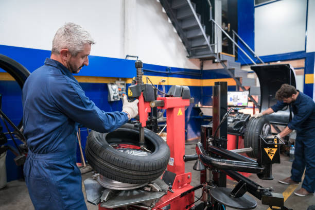 istock Car mechanics balancing car wheel 1312472347