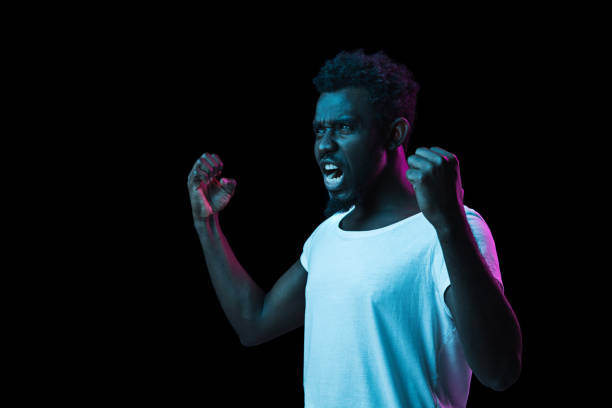 istock Young African-American man isolated on dark background in neon light 1312475946