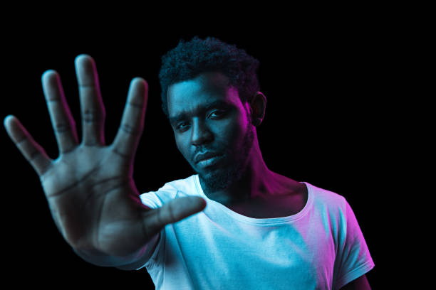 istock Young African-American man isolated on dark background in neon light 1312475950