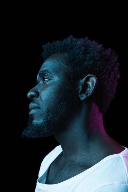 istock Young African-American man isolated on dark background in neon light 1312475952