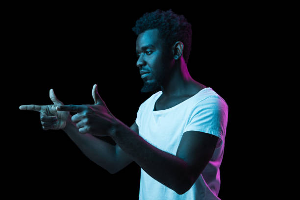 istock Young African-American man isolated on dark background in neon light 1312475961