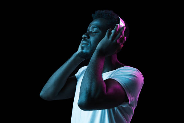 istock Young African-American man isolated on dark background in neon light 1312475974