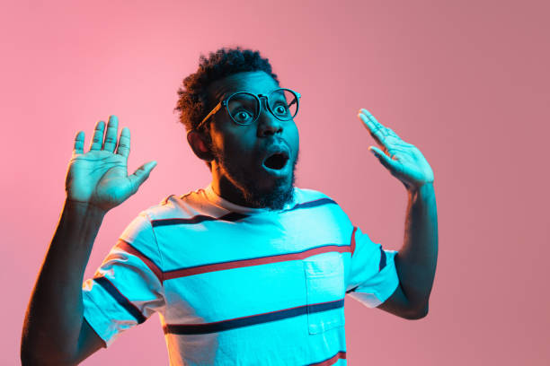 istock Young African-American man isolated on pink background in neon light 1312476004