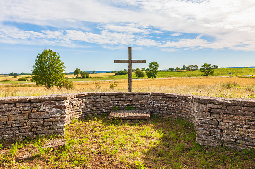 A stone cross perched on a grassy hill in Skogskrykogarden Cemetery in Stockholm.