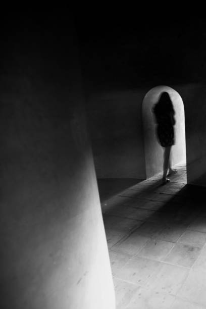 istock Unknown female walks alone in the dark ancient basement. 1312478080