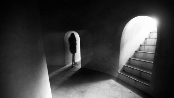 istock Unknown female walks alone in the dark ancient basement. 1312478099