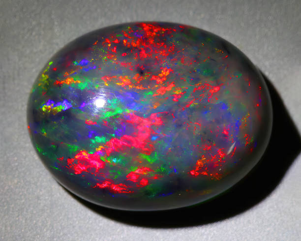 Natural gemstone black opal on gray background Natural gemstone black opal on gray background opal photos stock pictures, royalty-free photos & images