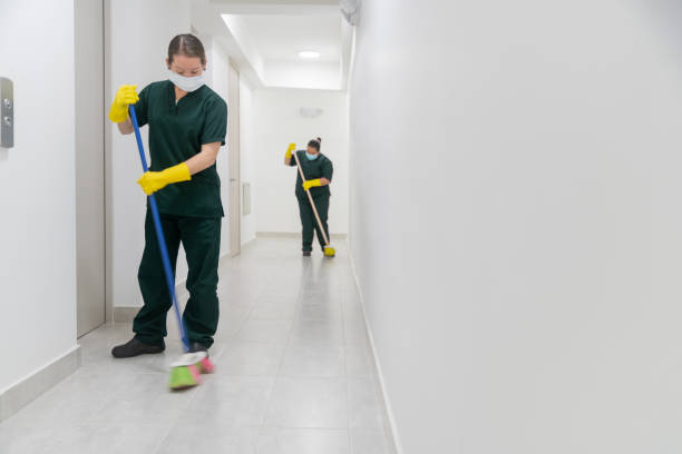 istock Cleaners working at an office building sweeping the floor while wearing facemasks 1312481717
