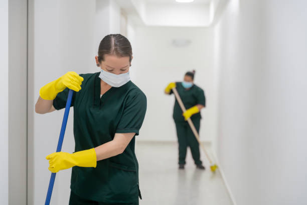 istock Cleaners wearing facemasks while working at an office building sweeping the floors 1312481720
