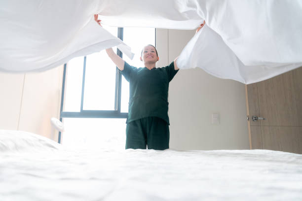 istock Happy cleaner working at a hotel and doing the bed 1312481735