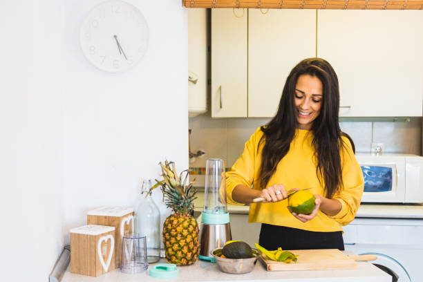 istock Young beautiful woman preparing a healthy smoothie 1312483818