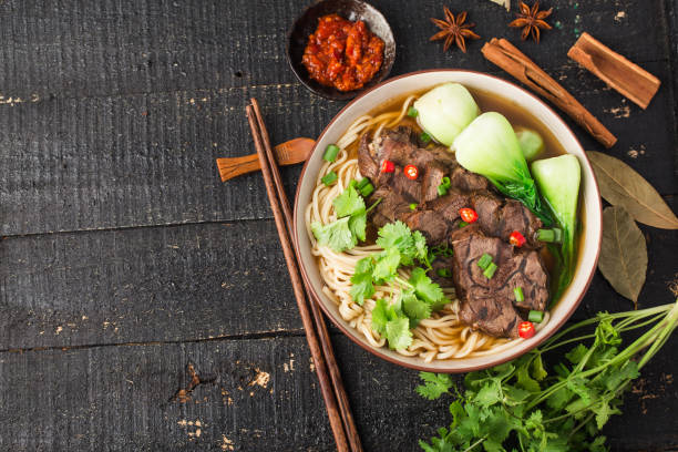 istock Spicy red soup beef noodle in a bowl on wooden table 1312485064
