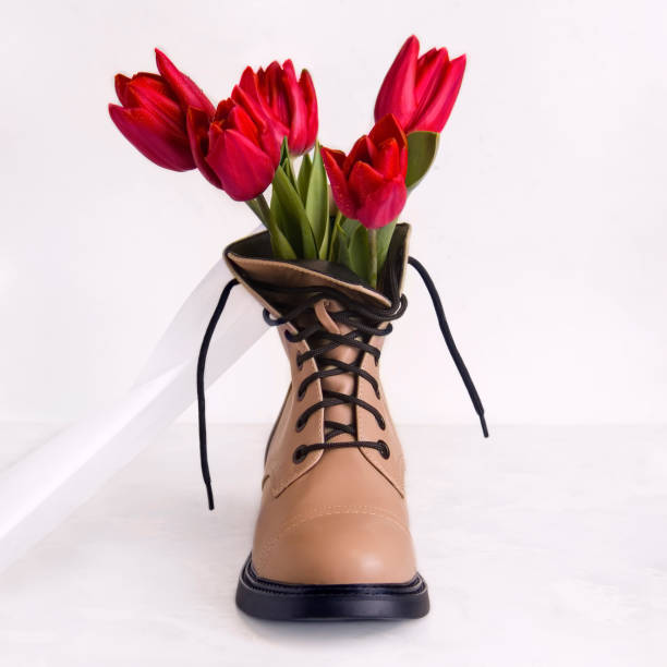 istock Spring concept. Beige shoes with tulips on a white background 1312485219