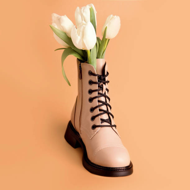 istock Spring shoes. Boot with white tulips on a beige background 1312485231