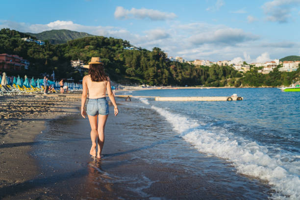 istock Woman walking on beach 1312485425