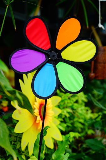 Colorful Toy wind turbine in green garden