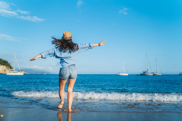 istock Woman spreading arms at the beach 1312486146