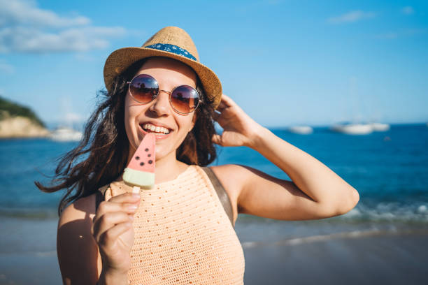 istock Woman eating ice-cream on beach 1312486434