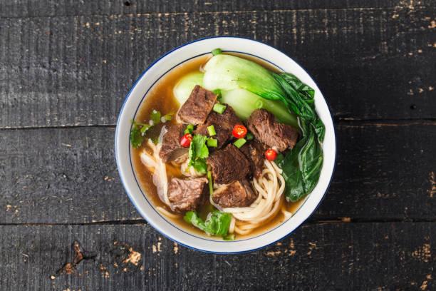 istock Spicy red soup beef noodle in a bowl on wooden table 1312487021