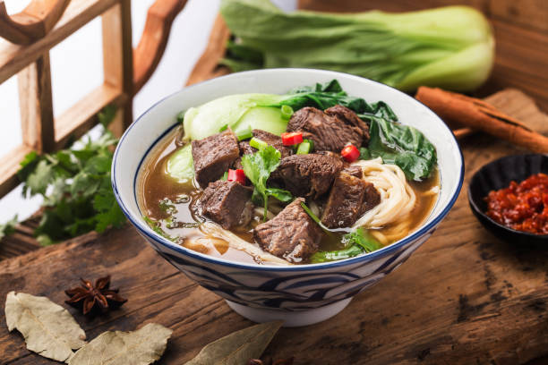 istock Spicy red soup beef noodle in a bowl on wooden table 1312487066