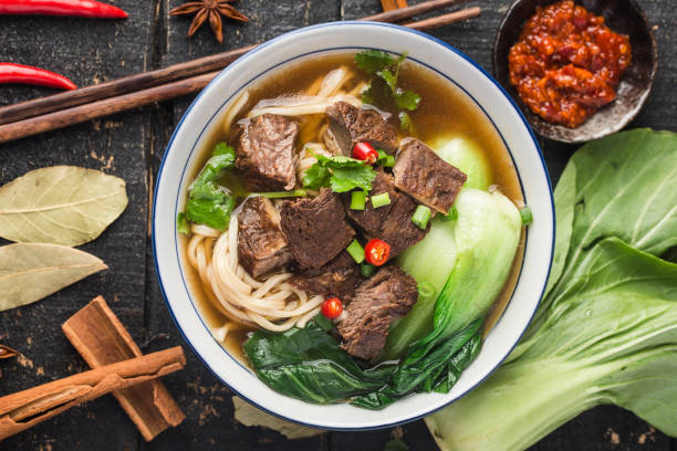 istock Spicy red soup beef noodle in a bowl on wooden table 1312487787