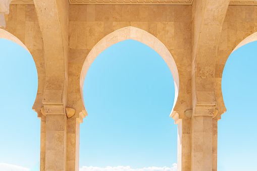 Arabian-style arch decorated with Moroccan patterns on the blue cloudless sky background