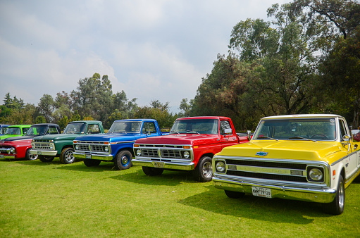Mexico - September, 2018: Vintage car show and exhibition of Chevrolet pick up and Ford cars outdoors. Red and yellow classic vehicle parked in a retro event.
