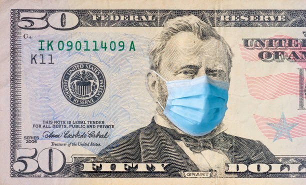istock Fifty dollar bill with medical face mask on Benjamin Franklin. 1312492550