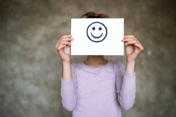 istock Child holding a smile face drawing. Happy emotion. 1312492810