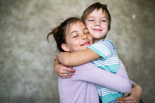 Happy, smile and portrait of children siblings bonding outdoor in a backyard garden together. Happiness, love and kids standing and playing outside in the sun for adventure while on summer holiday.