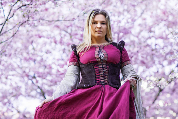 Beautiful fantasy Russian woman dressed in a beautiful traditional dress in a cherry tree forest