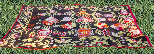 Bright vintage handmade carpet on the tall green grass.