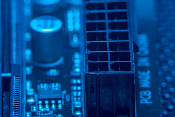 istock High tech dark background with elements of a computer motherboard in soft focus under high magnification. Close-up of a power connector on a home computer board. 1312498722