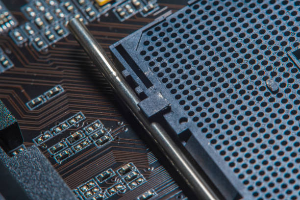 istock High tech dark background with elements of a computer motherboard in soft focus under high magnification. A slot for a processor with a lever for locking onto the home computer board. 1312498725