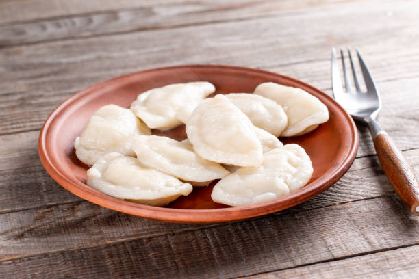 Dumplings with potato filling. Dumplings in a clay plate. Free space for text Dumplings with potato filling. Dumplings in a clay plate. Free space for text. Rustic wooden background. russian pelmeni stock pictures, royalty-free photos & images
