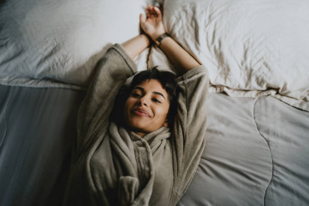 giovane donna appoggiata sdraiata a letto - bedtime foto e immagini stock