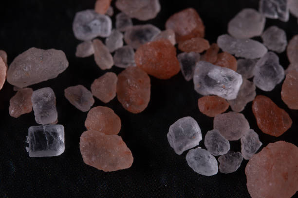 istock Himalayan pink salt in crystals above a gray stone on black background. 1312501405