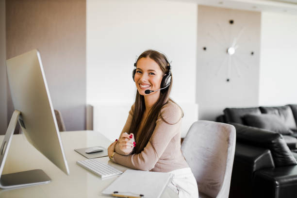 istock Happy woman with headset having video call and working on computer in her home office 1312506349