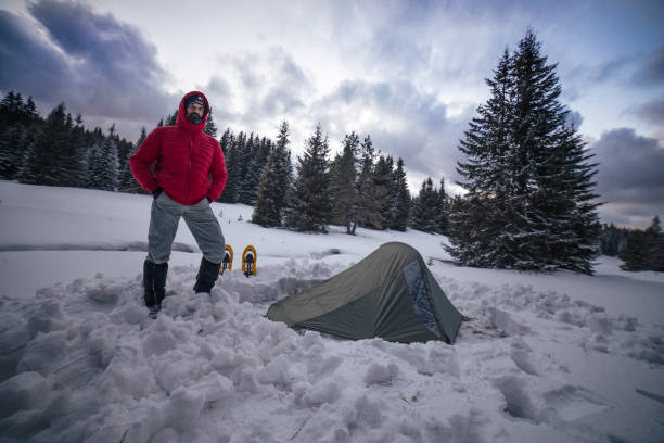 istock Tourist setting up tent while camping in winter mountain. Alone in nature while COVID-19 pandemic. Mental health and life balance. 1312510334