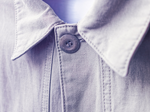 A khaki denim jacket collar is buttoned up. The fabric texture is clearly visible. Closeup view. Fashion concept.